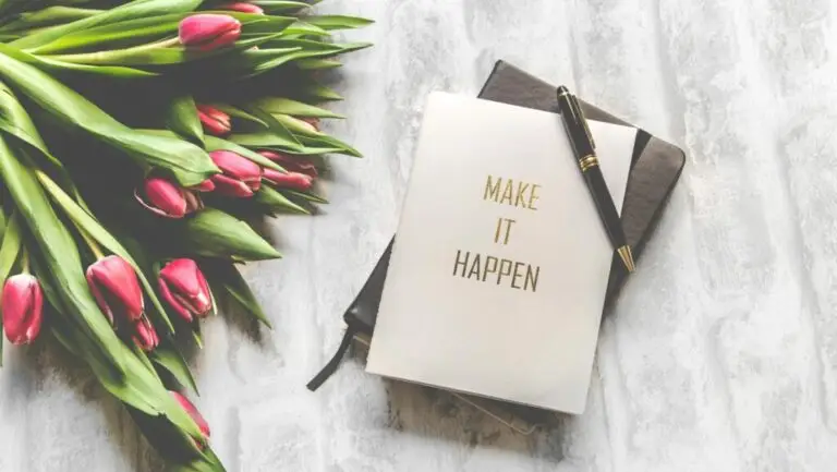 A notebook with 'Make It Happen' inscription beside a bouquet of pink tulips, capturing inspiration, garden, blog
